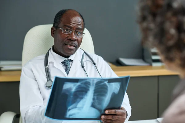 Pewny Siebie Afro Amerykański Radiolog Prześwietleniem Płuc Rozmawiający Dojrzałą Pacjentką — Zdjęcie stockowe
