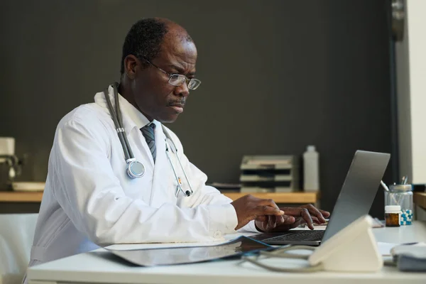 Starší Africký Americký Muž Virtuální Zdravotní Asistent Laboratorní Plášť Psaní — Stock fotografie