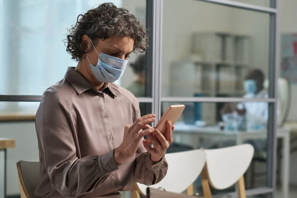 Mulher Madura Casualwear Inteligente Máscara Protetora Mensagens Texto Smartphone Enquanto — Fotografia de Stock