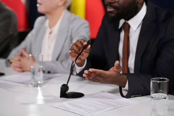 아프리카 미국인 대표가 마이크 앉아서 컨퍼런스에서 앞에서 연설을 있습니다 — 스톡 사진