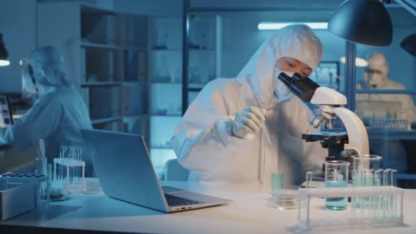 Beyaz Tehlikeli Madde Giysisi Solunum Cihazı Giymiş Mikroskop Bilgisayar Kullanarak — Stok video