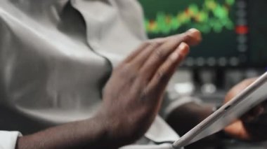 Menkul kıymetler borsasında dijital tablet kullanarak çalışan tanınmayan siyahi uzmanların yakın plan fotoğrafları.