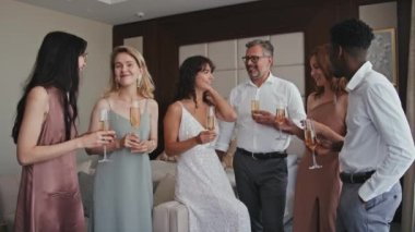 Genç gelinin, etnik çeşitlilikteki ailelerin ve arkadaşlarının uzun ve yavaş çekimleri düğün sabahı ellerinde şampanya kadehleri, konuşmalar ve sonra da kameraya bakmaları için bir araya geldi.