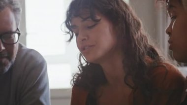 Beyaz bir kadın gelini ve babasıyla düğün hazırlıklarını tartışıyor, dijital tabletten resim izliyor.