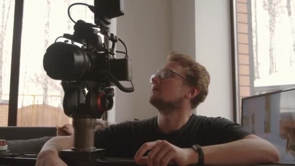 Ramię Góry Młodego Człowieka Okularach Kręcącego Coś Pomocą Profesjonalnej Kamery — Wideo stockowe
