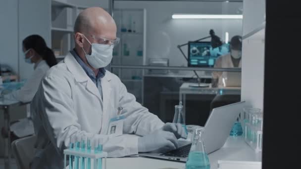 Beyaz Önlüklü Yüz Maskeli Eldivenli Yetişkin Erkek Laboratuvar Teknisyeninin Belden — Stok video