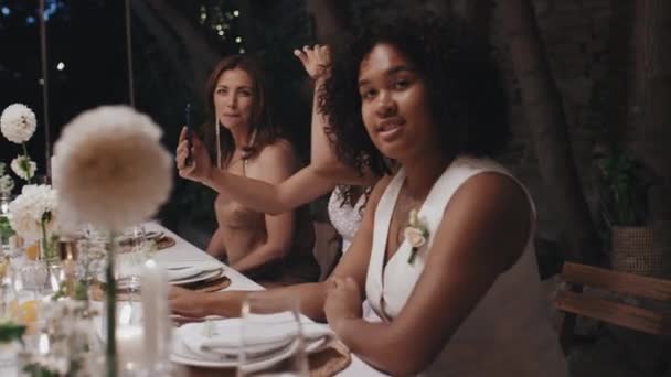 现代非洲裔美国女同性恋者新婚夫妇坐在咖啡馆的节日桌旁 在镜头前摆出有趣的姿势 — 图库视频影像