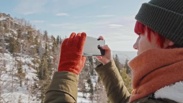 晴れた冬の日に山の景色を撮影した赤い髪の若い女性のクローズアップ — ストック動画