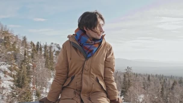 Yakışıklı Beyaz Bir Adam Dağın Tepesindeki Platformda Rahatça Oturup Kameraya — Stok video