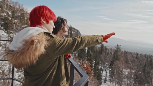 山の上の展望台でリラックスして景色を楽しみ おしゃべりするのが好きなスタイリッシュな若者と女性 — ストック動画