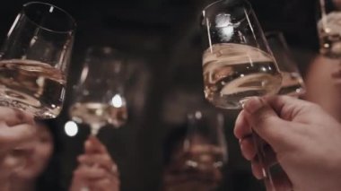 Kadehleri köpüklü şarap ya da şampanya ile tokuşturup bir şeyleri kutlayan insanların seçici odak noktası.
