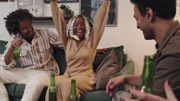 Веселая Молодая Черная Женщина Сидящая Диване Гостиной Выигрывает Раунд Угадывания — стоковое видео