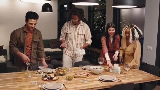 Группа Современных Молодых Мультиэтнических Мужчин Женщин Накрывают Стол Гостиной Ужин — стоковое видео
