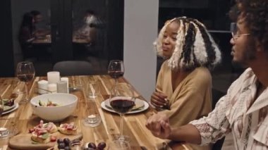 Bir grup modern etnik çeşitlilikte genç kadın ve erkek geceyi birlikte geçirir. Partide yemeğin tadını çıkarırlar.