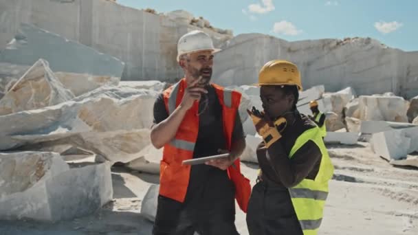 Dojrzały Brygadzista Kaukaski Inżynier Afroamerykanin Spacerujący Terenie Kamieniołomu Marmuru Omawiający — Wideo stockowe