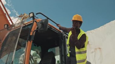 Taş ocağında kazı görevlisi olarak çalışan Afrikalı Amerikalı bir kadın iş arkadaşına telsiz kullanarak bir şeyler anlatıyor.