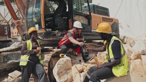 Grupa Trzech Zróżnicowanych Etnicznie Pracowników Kamieniołomów Siedzących Stojących Przy Koparce — Wideo stockowe