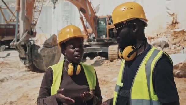 アフリカ系アメリカ人の女性やエンジニアが大理石の石を安全に抽出する方法を採石場労働者に説明 — ストック動画