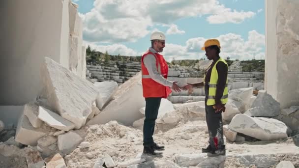 成熟した白人男性の長いショット握手でアフリカ系アメリカ人女性労働者を迎える 大理石の採石場の概念での作業日 — ストック動画