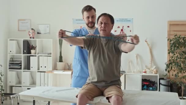 Olgun Hasta Kanepede Oturup Doktorla Birlikte Sırtını Çalıştırmak Için Lastik — Stok video