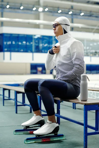 제복을 스케이트를 단거리 선수가 벤치에 경기장에서 훈련을 휴식을 취한다 — 스톡 사진