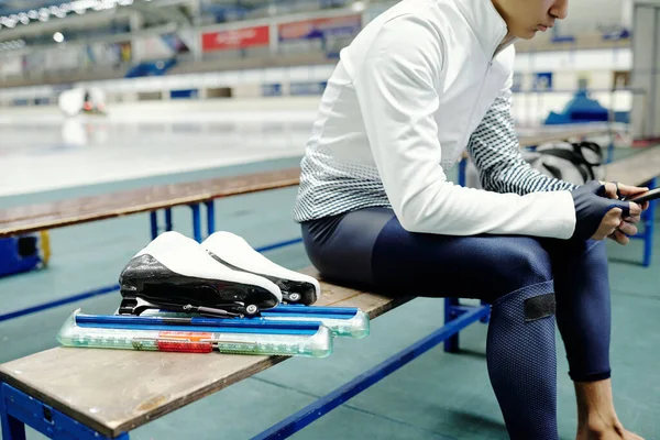 스포츠 유니폼을 경기장 청소년 아이스 스케이트 선수의 훈련을 휴대폰으로 메시지를 — 스톡 사진