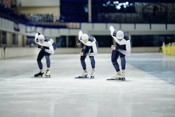 훈련이나 경쟁중에 스케이트장에서 스피드 스케이팅을 하면서 앞으로 구부리고 선수들의 그룹의 — 스톡 사진