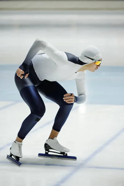 身穿速滑制服的年轻人在冰场准备短道比赛时弯腰滑行 — 图库照片