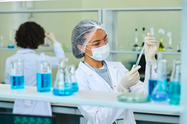 Virologista Farmacóloga Joven Sosteniendo Frasco Con Sustancia Química Líquida Azul — Foto de Stock