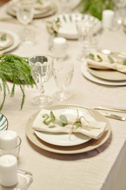 Tabaklar, mumlar, flütler ve yeşil bitkilerle dolu yemek masasının bir kısmı aile kutlamaları için oturma odasında ya da mutfakta servis ediliyor.