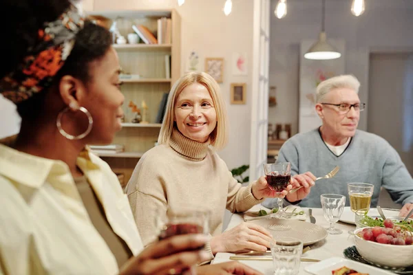 Feliz Mulher Loira Madura Com Copo Vinho Tinto Caseiro Conversando — Fotografia de Stock