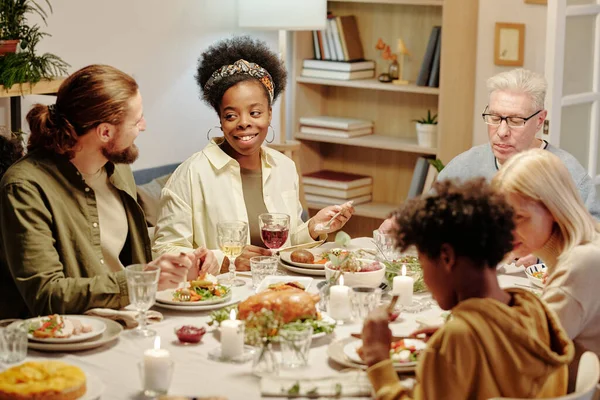 Feliz Casal Intercultural Jovem Conversando Mesa Servida Enquanto Desfruta Jantar — Fotografia de Stock