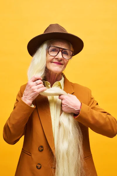 Старшая Женщина Длинными Белыми Волосами Стоящими Перед Камерой Изоляции Жёлтом — стоковое фото