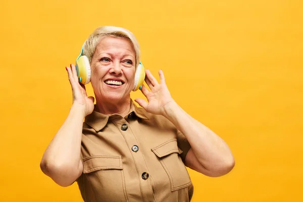 Radosna Dojrzała Kobieta Krótkimi Blond Włosami Ciesząca Się Muzyką Słuchawkach — Zdjęcie stockowe