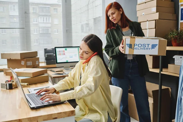 Ehrenamtliche Helferin Trägt Schachtel Während Sie Ihrem Geschäftigen Kollegen Vorbeigeht — Stockfoto