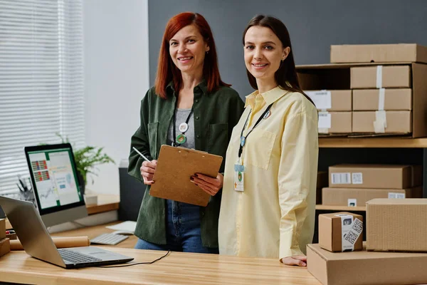 Två Framgångsrika Kvinnliga Volontärer Står Vid Arbetsplatsen Förrådet Och Tittar — Stockfoto