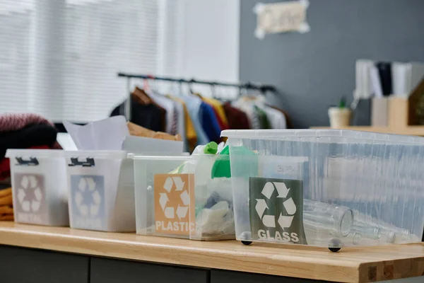 困っている人を支援するボランティア団体の事務所の机の上に立つ分別ごみ用プラスチック容器のグループ — ストック写真