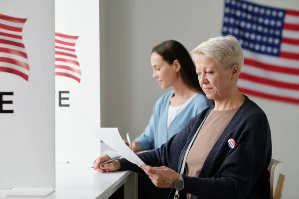 Reife Wählerinnen Schauen Sich Die Kandidatenliste Während Sie Der Wahlkabine — Stockfoto