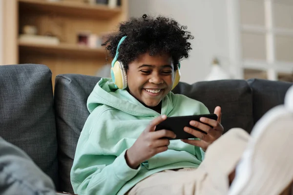 Smiling Boy Headphones Lookng Smartphone Screen Leisure While Sitting Sofa — Stock Photo, Image