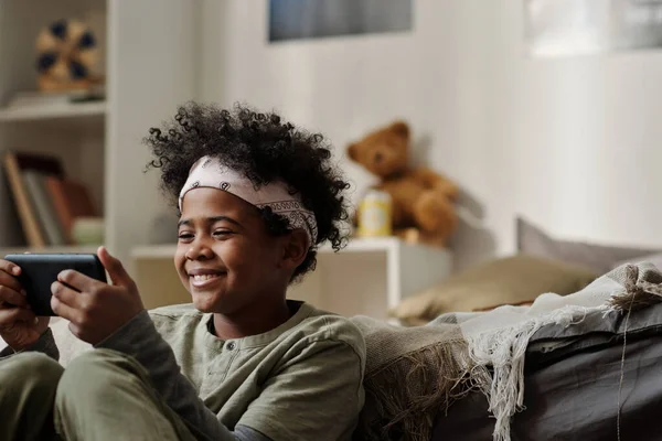 Lächelnder Afroamerikanischer Junge Mit Stirnband Schaut Auf Smartphone Bildschirm Während — Stockfoto