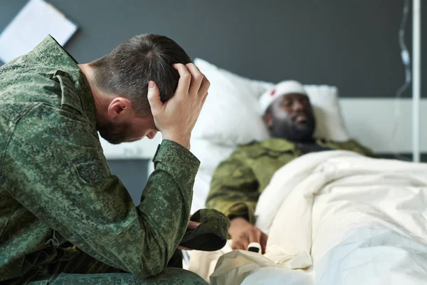 Junger Besorgter Soldat Tarnkleidung Berührt Kopf Während Bei Seinem Freund — Stockfoto