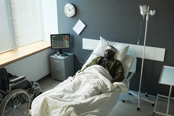 Ung Afroamerikansk Skadad Man Kamouflage Liggande Sängen Mellan Dropper Och — Stockfoto