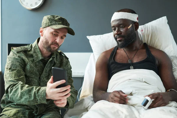 Ung Soldat Militär Uniform Visar Nya Foton Smartphone Till Skadad — Stockfoto