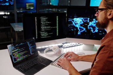 Yeni yazılımın yardımıyla verileri çözerken masaüstü bilgisayar klavyesinde yazan genç programcı veya bilişim mühendisinin yakın plan görüntüsü