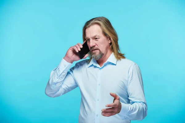 Magabiztos Érett Üzletember Komoly Beszélgetés Mobiltelefon Álló Kék Háttér — Stock Fotó