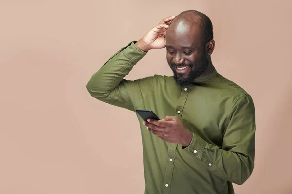 Hombre Afroamericano Camisa Verde Comunicándose Línea Usando Teléfono Inteligente Mientras — Foto de Stock