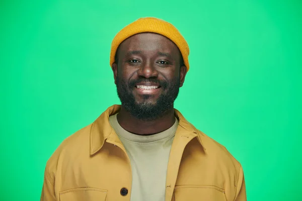 Portret Uśmiechniętego Afroamerykanina Żółtym Kapeluszu Patrzącego Kamerę Stojącą Zielonym Tle — Zdjęcie stockowe