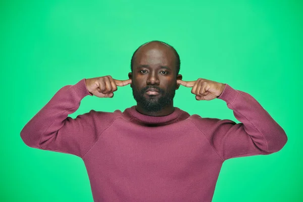 Portret Afroamerykanina Patrzącego Kamerę Zasłaniającego Uszy Zignorować Odizolowane Zielonym Tle — Zdjęcie stockowe