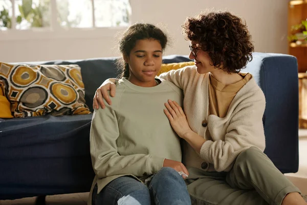 Lächelnde Mutter Gespräch Mit Ihrer Adoptivtochter Während Sie Wohnzimmer Auf — Stockfoto