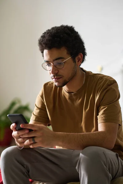 Függőleges Kép Tinédzser Fiú Szemüveges Olvasás Üzenet Okostelefon Hálószobában — Stock Fotó